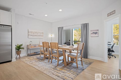 A dining room with a table and chairs.