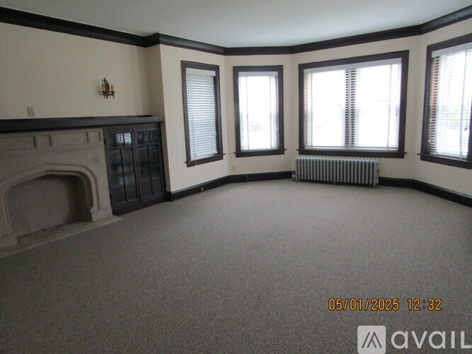 A living room with a fireplace and a carpeted floor.