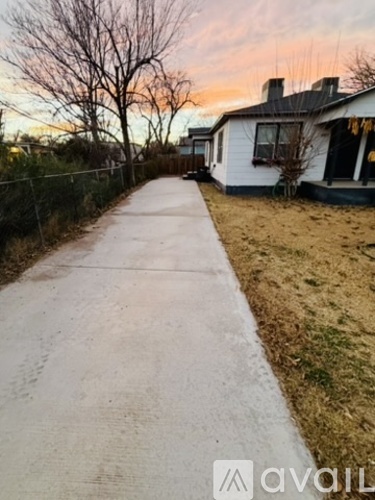 A white house with a white fence and a white pathway leading to it.