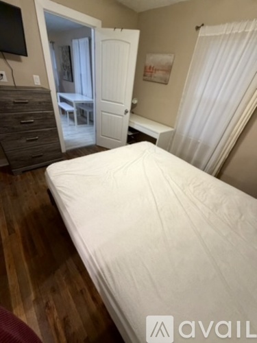 A bedroom with a large bed and a dresser.