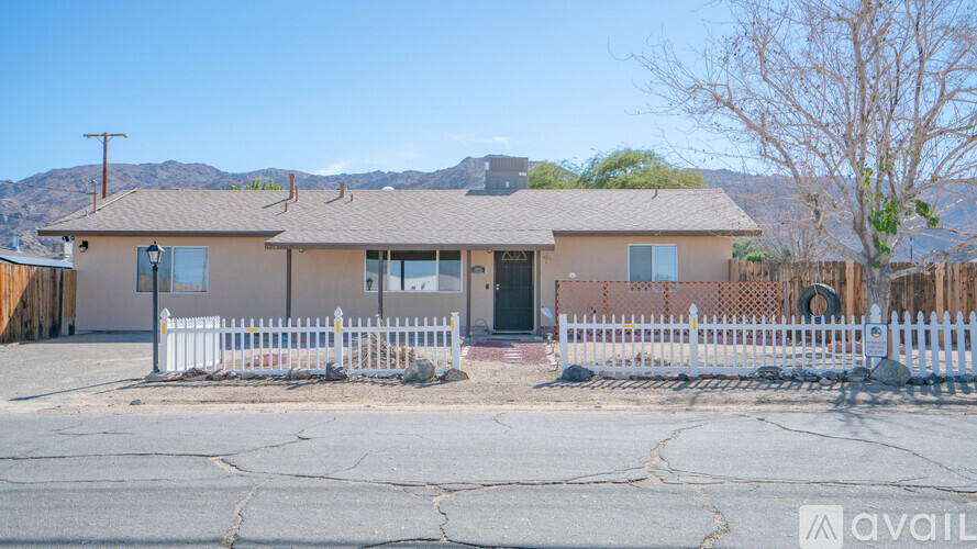 A house with a white picket fence in front of it.