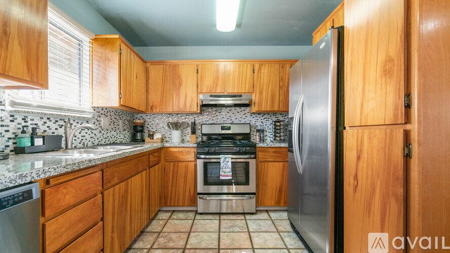 A kitchen with wooden cabinets and a tiled backsplash.