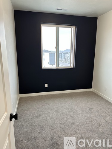 A room with a window and carpeted floor.