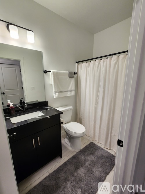 A bathroom with a toilet, sink, and shower.
