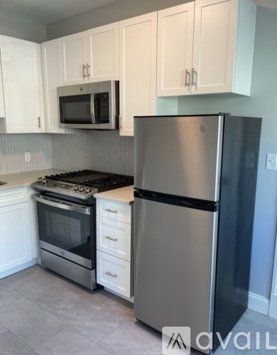 A kitchen with a stainless steel refrigerator, oven, and microwave.