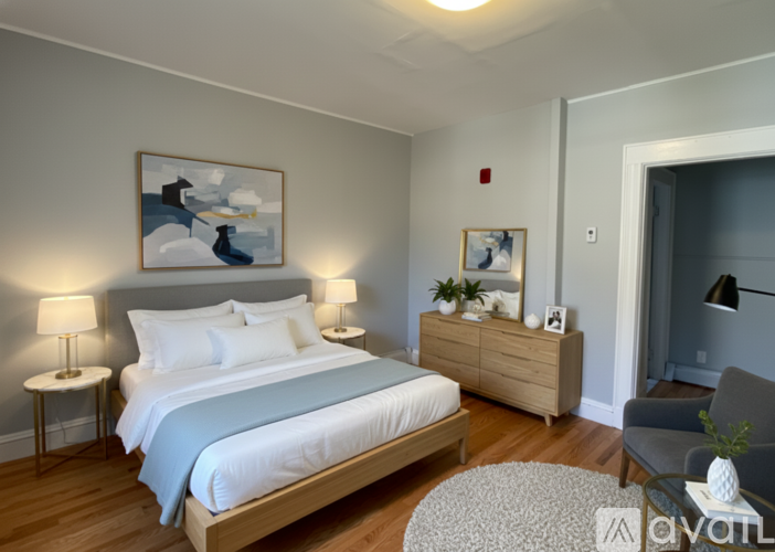 A bedroom with a bed, nightstand, and lamp.