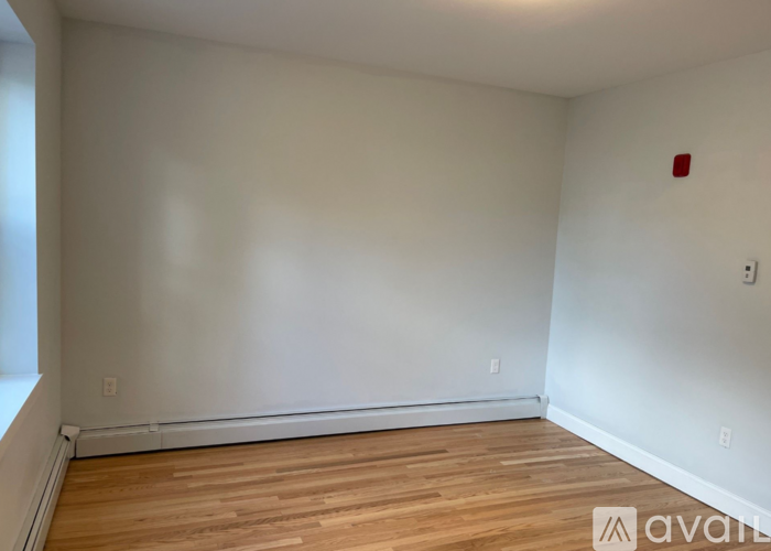 A room with wooden flooring and white walls.