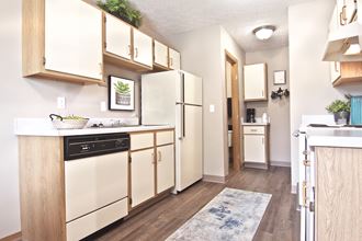 a spacious kitchen with white appliances and wooden cabinets