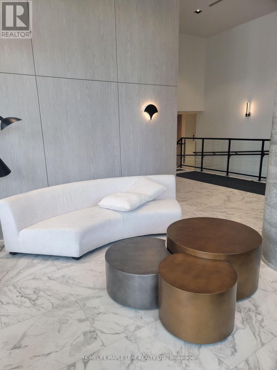 A white couch with a black metal table in front of a marble floor.