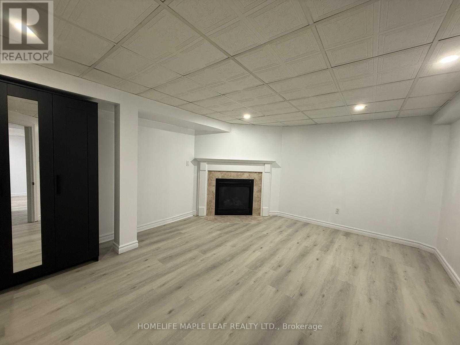 A room with a fireplace and wood flooring.