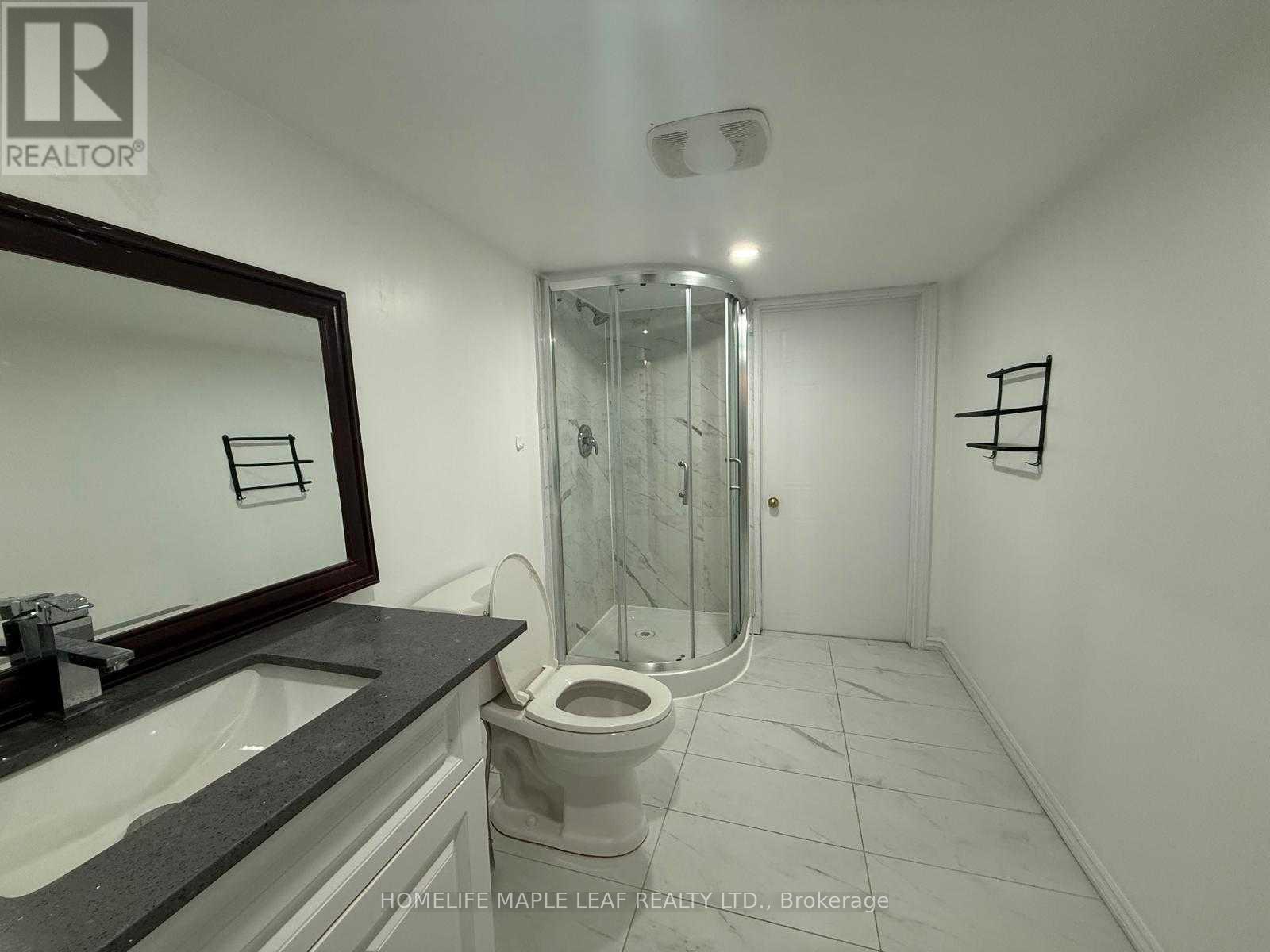 A bathroom with a toilet, sink, and shower.