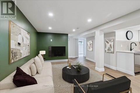 A living room with a white couch and a green wall.