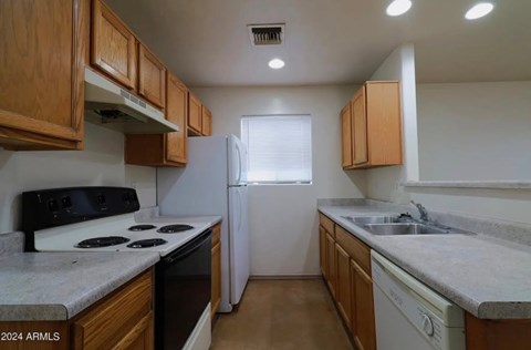 A kitchen with wooden cabinets and a white refrigerator.