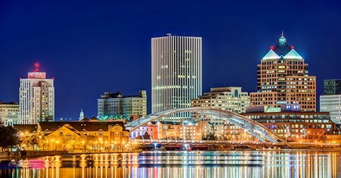 A cityscape at night with a reflection in the water.