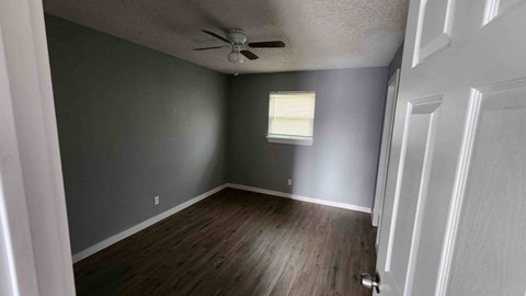 A room with a ceiling fan and a window.