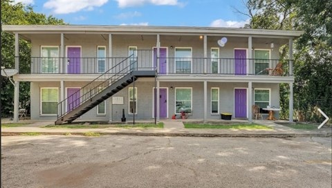 A building with purple doors and a staircase leading to the second floor.