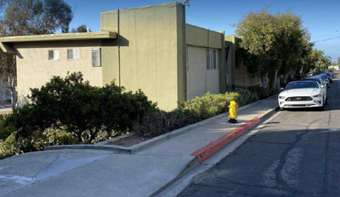 A white car is parked on the side of a street.