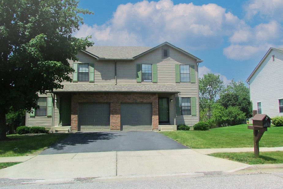 a house with a garage and a parking meter in front of it