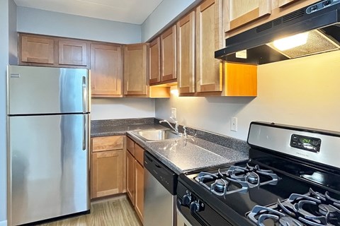 A kitchen with a stainless steel refrigerator and a black stove top oven.