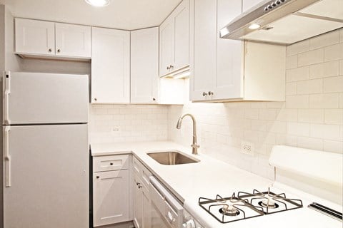 a white kitchen with white cabinets and a stove and a refrigerator