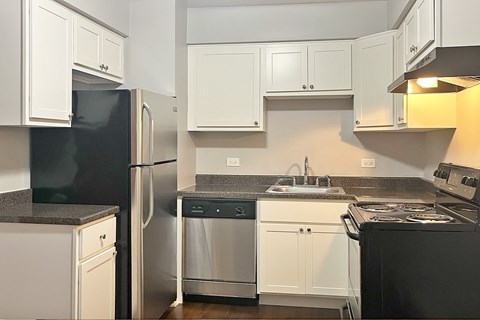 A kitchen with black appliances and white cabinets.