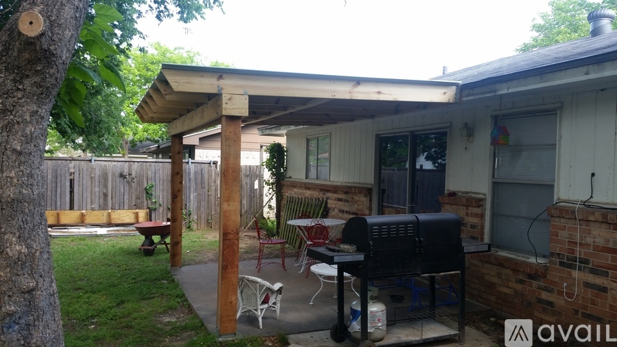 A patio with a table and chairs under a roof.