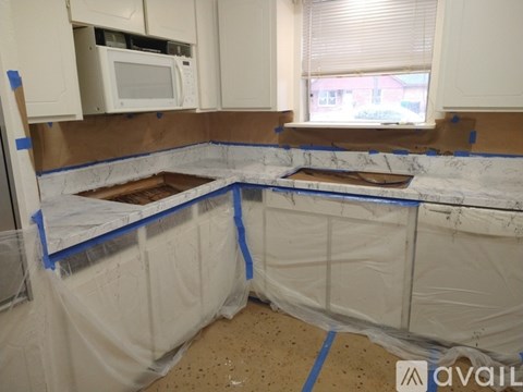 A kitchen undergoing renovation with white cabinets and a countertop.