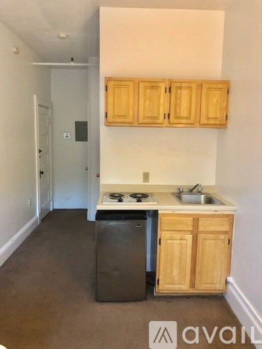 A kitchen with wooden cabinets and a stainless steel dishwasher.