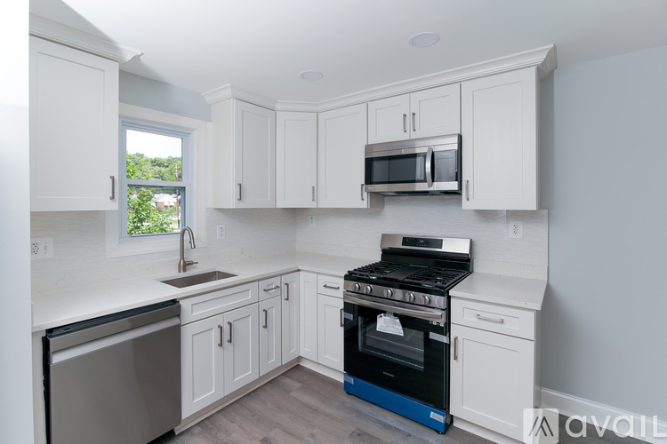 A kitchen with white cabinets and a blue stove.