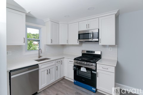 A kitchen with white cabinets and a blue stove.