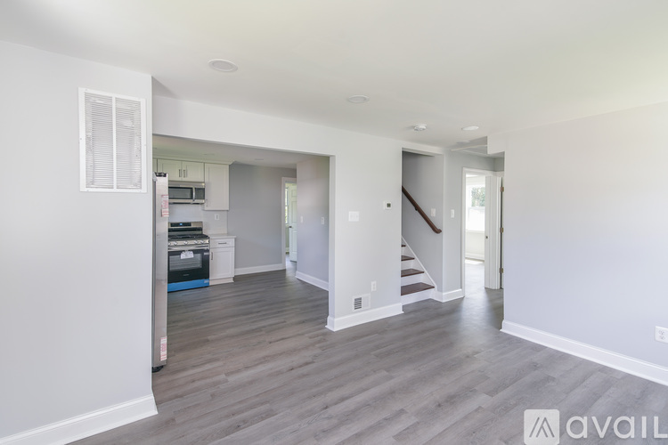 A spacious living room with a staircase leading to the upper floor.