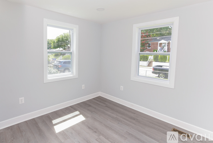 A room with a window and a picture on the wall.