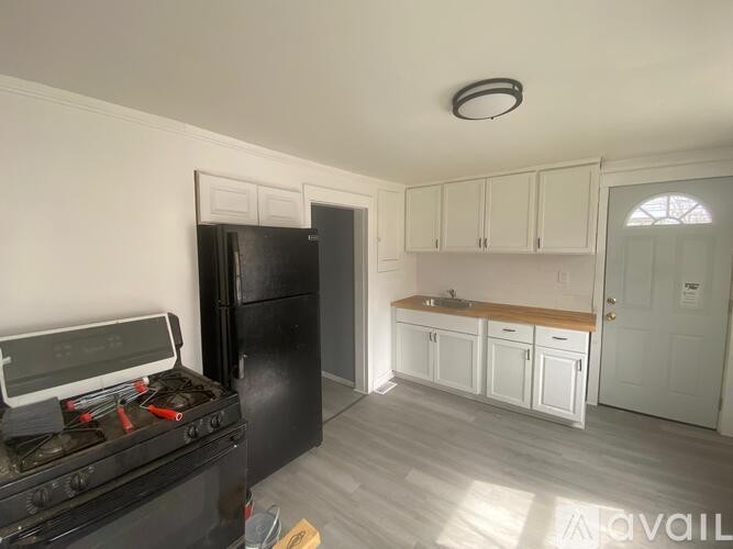 A kitchen with a black stove top oven and white cabinets.