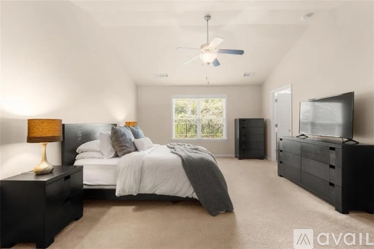 A bedroom with a bed, dresser, and television.