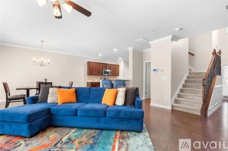 A blue couch with orange pillows in a living room.