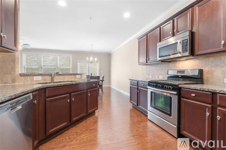 A kitchen with dark wood cabinets and stainless steel appliances.
