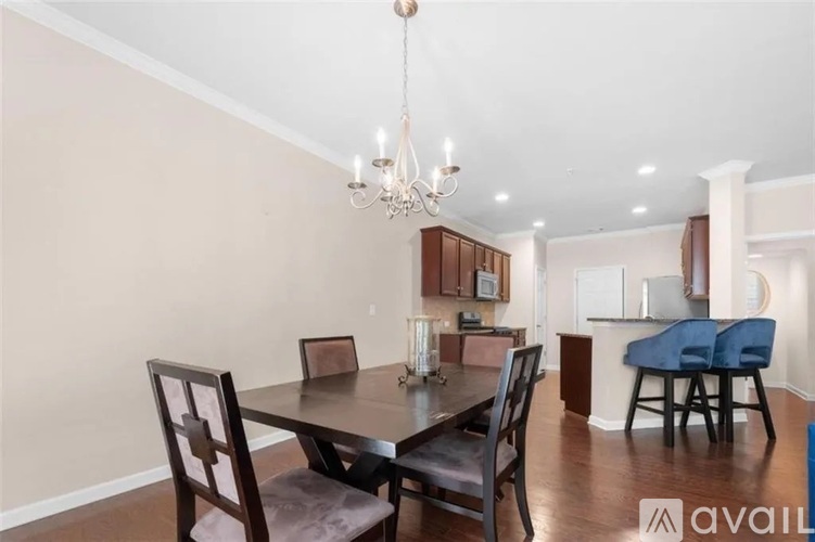 A dining room with a table set for two and a chandelier hanging from the ceiling.