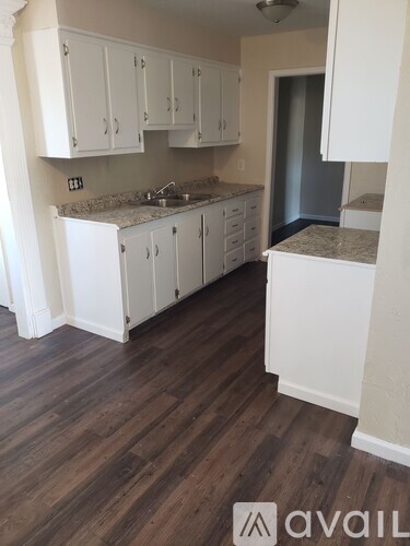 A kitchen with white cabinets and a granite countertop.