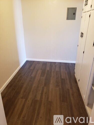 A room with wooden flooring and white walls.