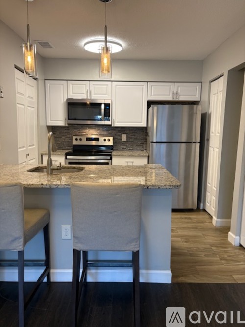 A kitchen with a granite countertop and a refrigerator.