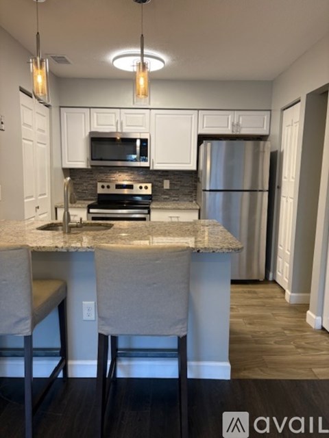 A kitchen with a granite countertop and a refrigerator.