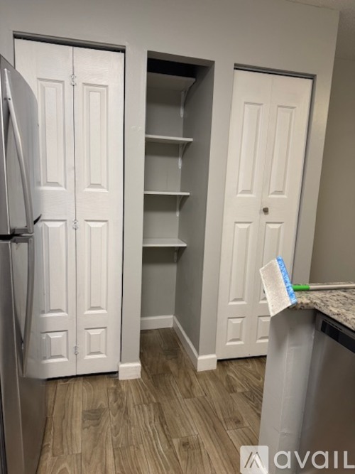 A kitchen with a white fridge and a white door.