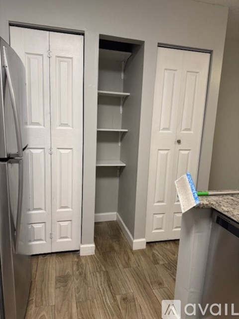A kitchen with a white fridge and a white door.