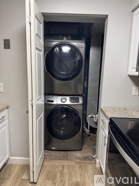 A washing machine is built into a cabinet in a kitchen.
