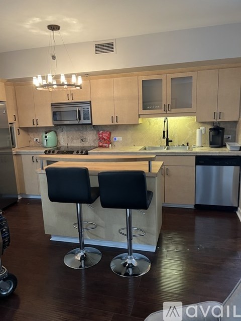 A kitchen with a bar stool in front of the island.