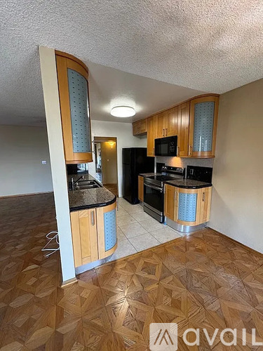 A kitchen with wooden cabinets and black appliances.