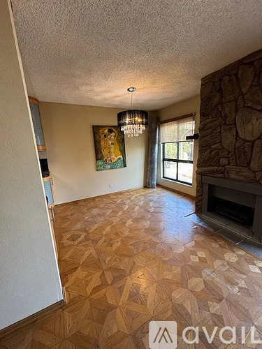 A living room with a stone fireplace and a painting of a lion.