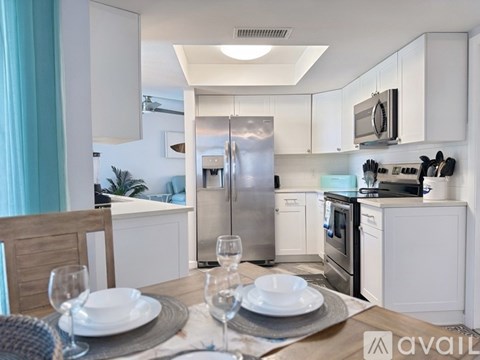 A modern kitchen with a dining table set for two.