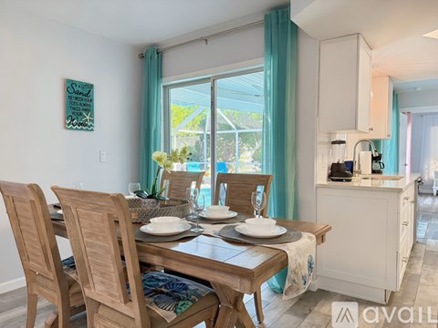 A dining room with a wooden table set for two.