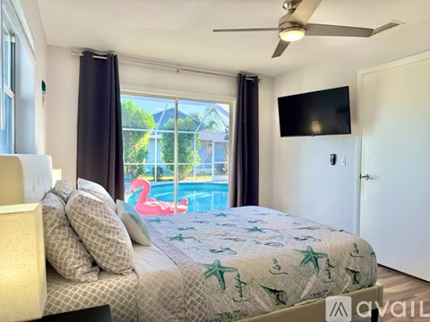 A bedroom with a large bed and a television mounted on the wall.